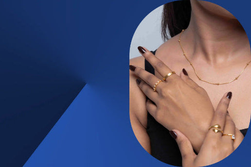 Close-up of hands wearing gold rings on a blue background